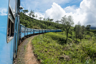 Train by railroad tracks against sky