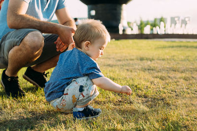 Rear view of father and son on field