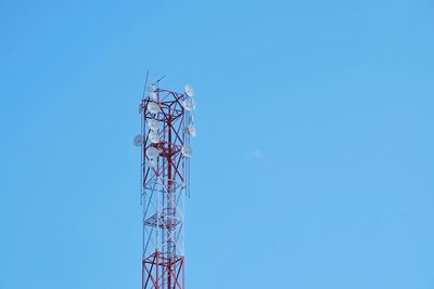 Low angle view of communications tower against blue sky