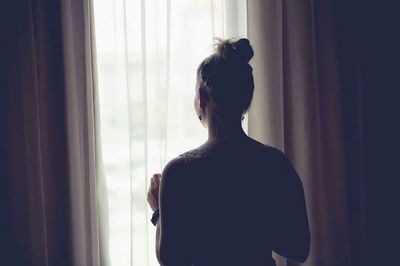 Woman looking through window