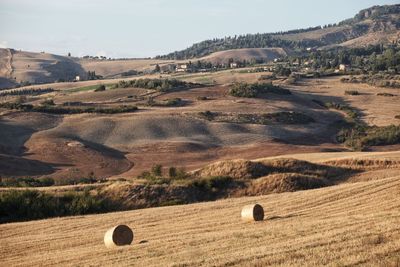 Hay bales on field against sky