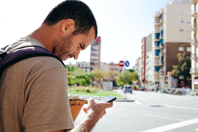 Close-up of man using mobile phone in city