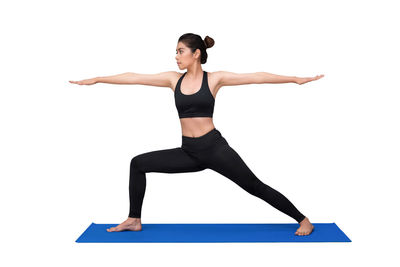 Full length of woman with arms raised against white background