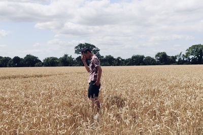 Full length of woman standing on field against sky