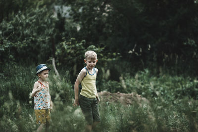 Rear view of boy standing in forest
