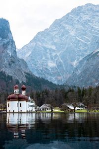 Scenic view of lake by snowcapped mountains against sky