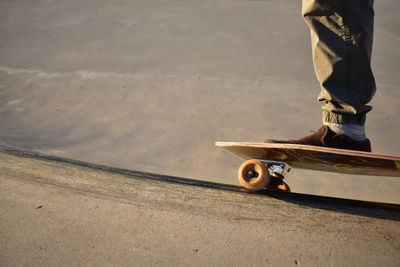 Low section of man skateboarding on road