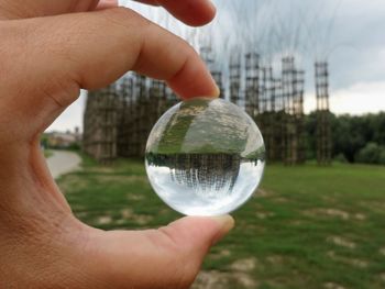 Cropped image of person holding ball glass