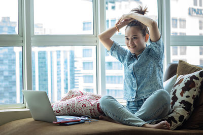 Young woman using mobile phone at home