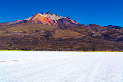Scenic view of mountains against clear blue sky