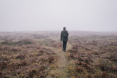 Rear view of man on landscape against sky