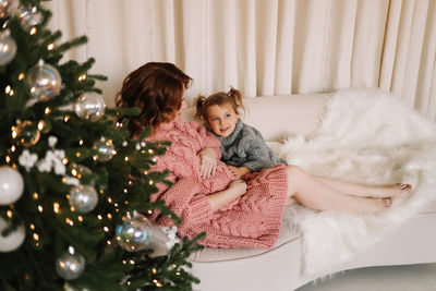 Portrait of smiling girl decorating christmas tree