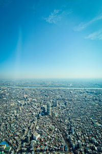 High angle view of city buildings against blue sky