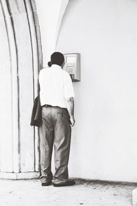Rear view of man standing against wall