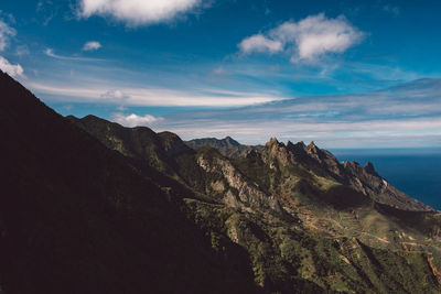 Scenic view of sea and mountains against sky