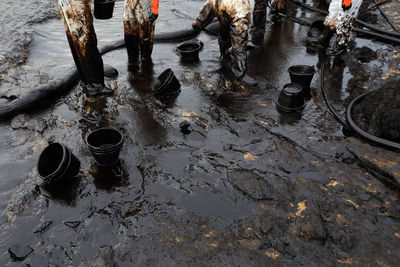 Low section of people standing on wet land