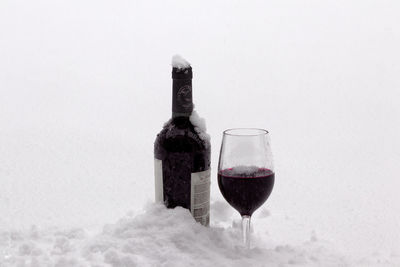 Glass of wine bottles against white background