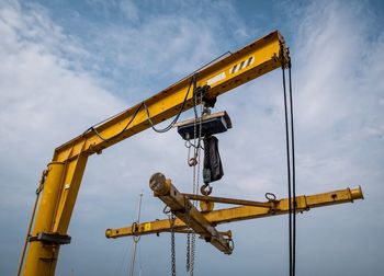 Low angle view of crane against sky