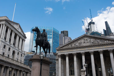 Low angle view of statue against buildings in city