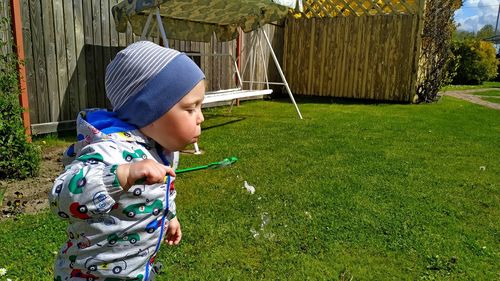 Little boy blowing air bubbles in the backyard