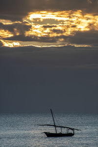 Silhouette boat in sea against sky during sunset