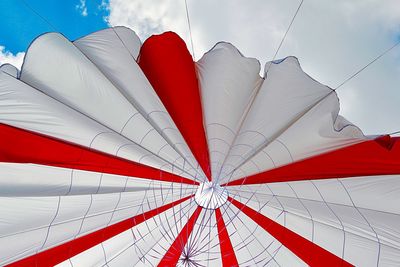 Low angle view of tent hanging against cloudy sky