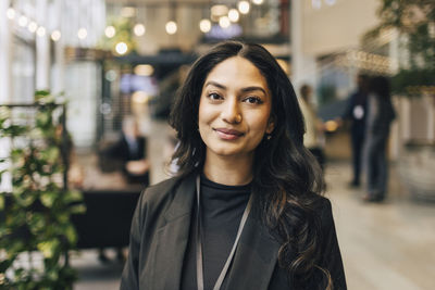 Close-up portrait of young female entrepreneur at networking event in convention center