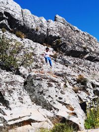 Low angle view of view of woman on rock against sky