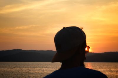 Rear view of silhouette man looking at sunset