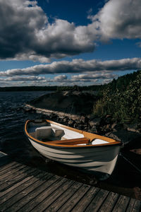 Boats moored on lake against sky