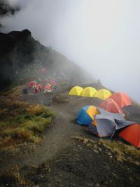 Multi colored tent on mountain against sky