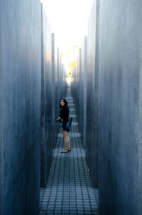 Rear view of a woman walking in narrow alley