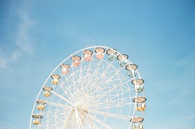 Low angle view of ferris wheel against blue sky