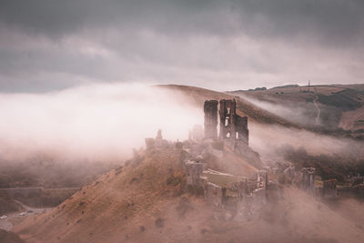 Corfe castle surrounded by mist in autumn