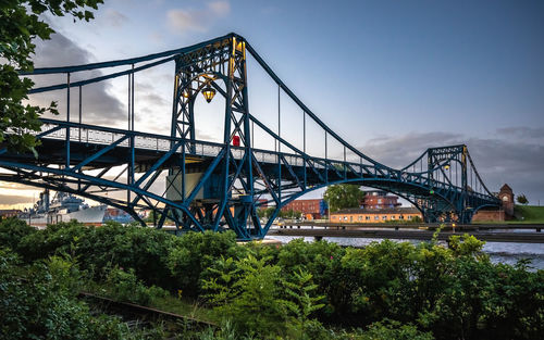 View of suspension bridge against cloudy sky