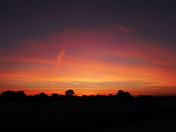 Scenic view of silhouette landscape against orange sky