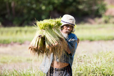 Man holding umbrella standing on field