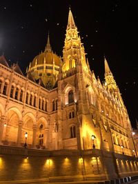 Low angle view of illuminated building against sky at night