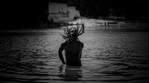 Rear view of woman standing in sea