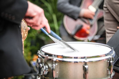 Midsection of man playing drum