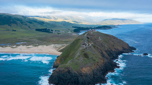 Scenic view of sea and mountains against sky