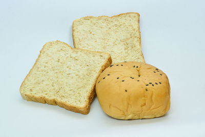 Close-up of chopped bread against white background