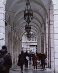 Rear view of people walking in corridor of building