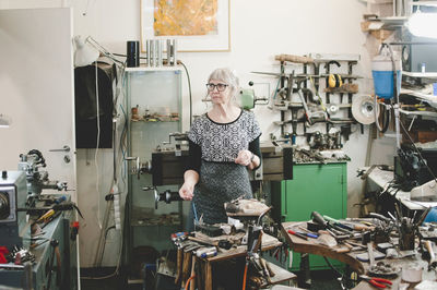 Senior female craftsperson working in jewelry workshop