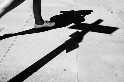 Shadow of man on street during sunny day