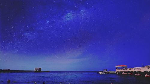 Scenic view of sea against star field at dusk