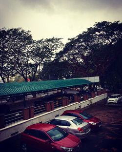 Cars on city street against sky