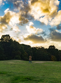 Man standing on golf course against sky