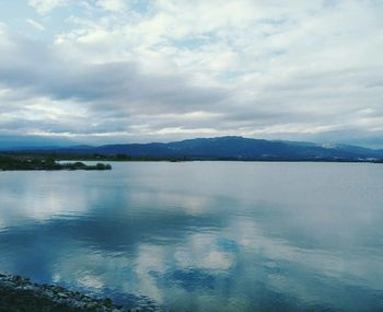 Scenic view of lake against cloudy sky