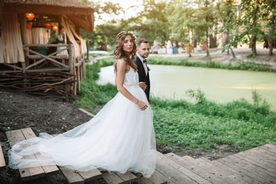 Bride and bridegroom standing on steps at park